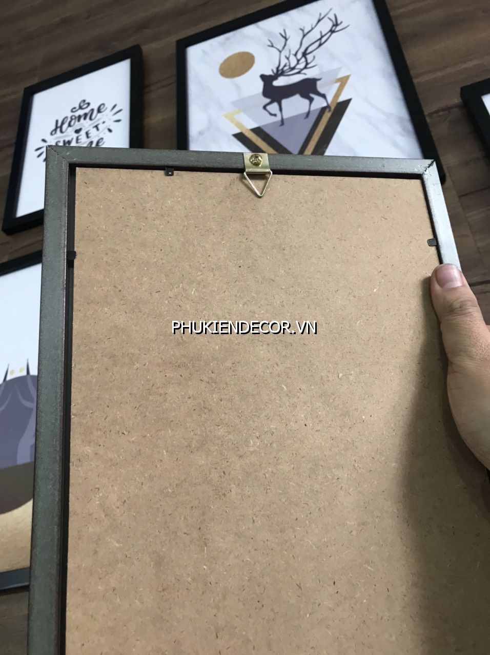 Nền gỗ - Phía sau có gắn móc treo tranh, sử dụng móc này treo lên đinh 3 chân vừa bắn lên tường Nền gỗ - Phía sau có gắn móc treo tranh, sử dụng móc này treo lên đinh 3 chân vừa bắn lên tường