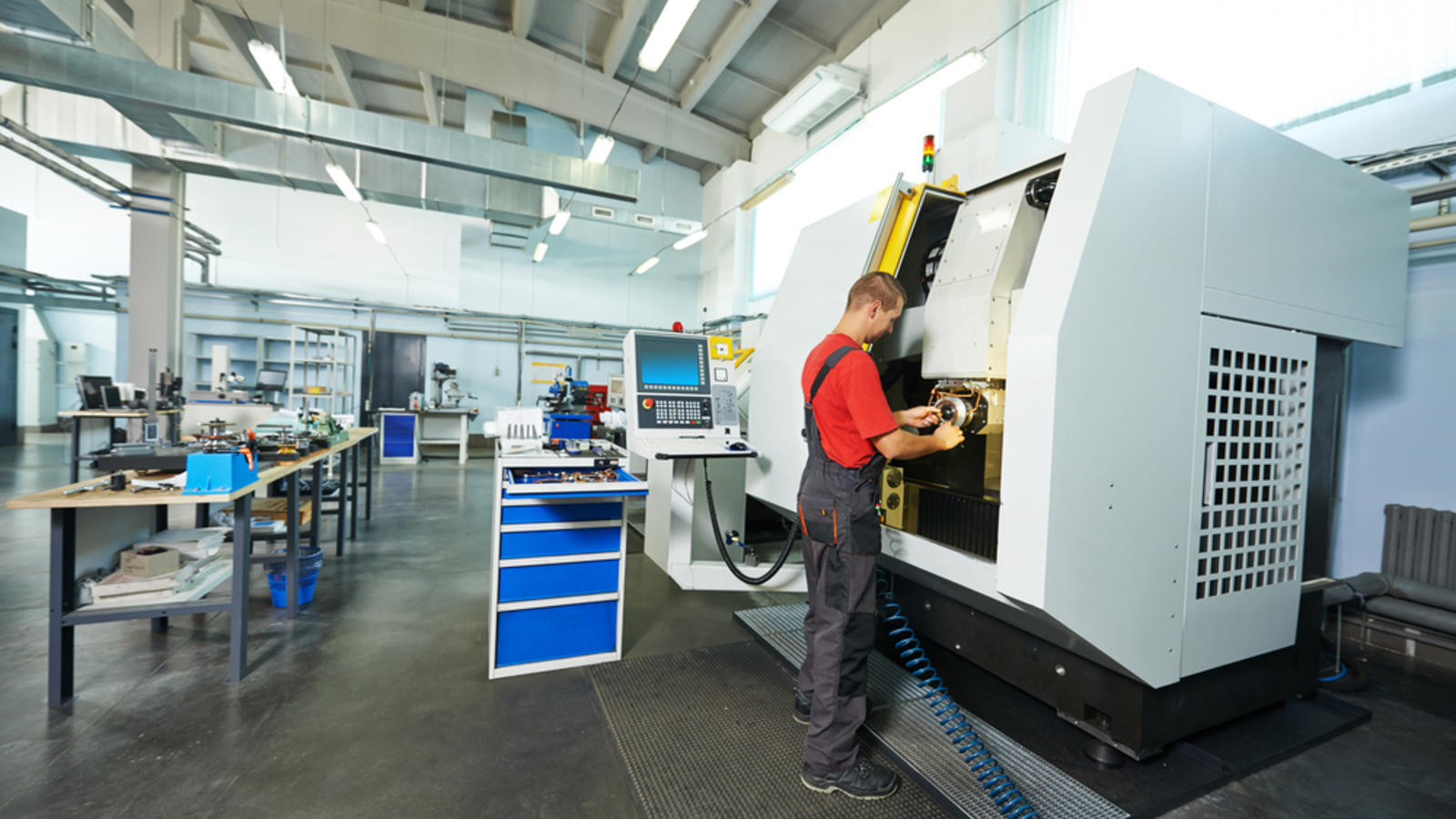 Công nhân đang vận hành máy CNC Công nhân đang vận hành máy CNC