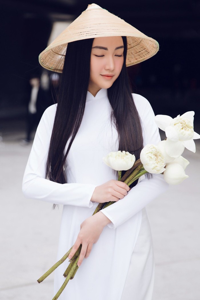 Tạo dáng với áo dài dịp Tết thần thái đủ các phong cách khác nhau > Chụp ảnh với nón lá