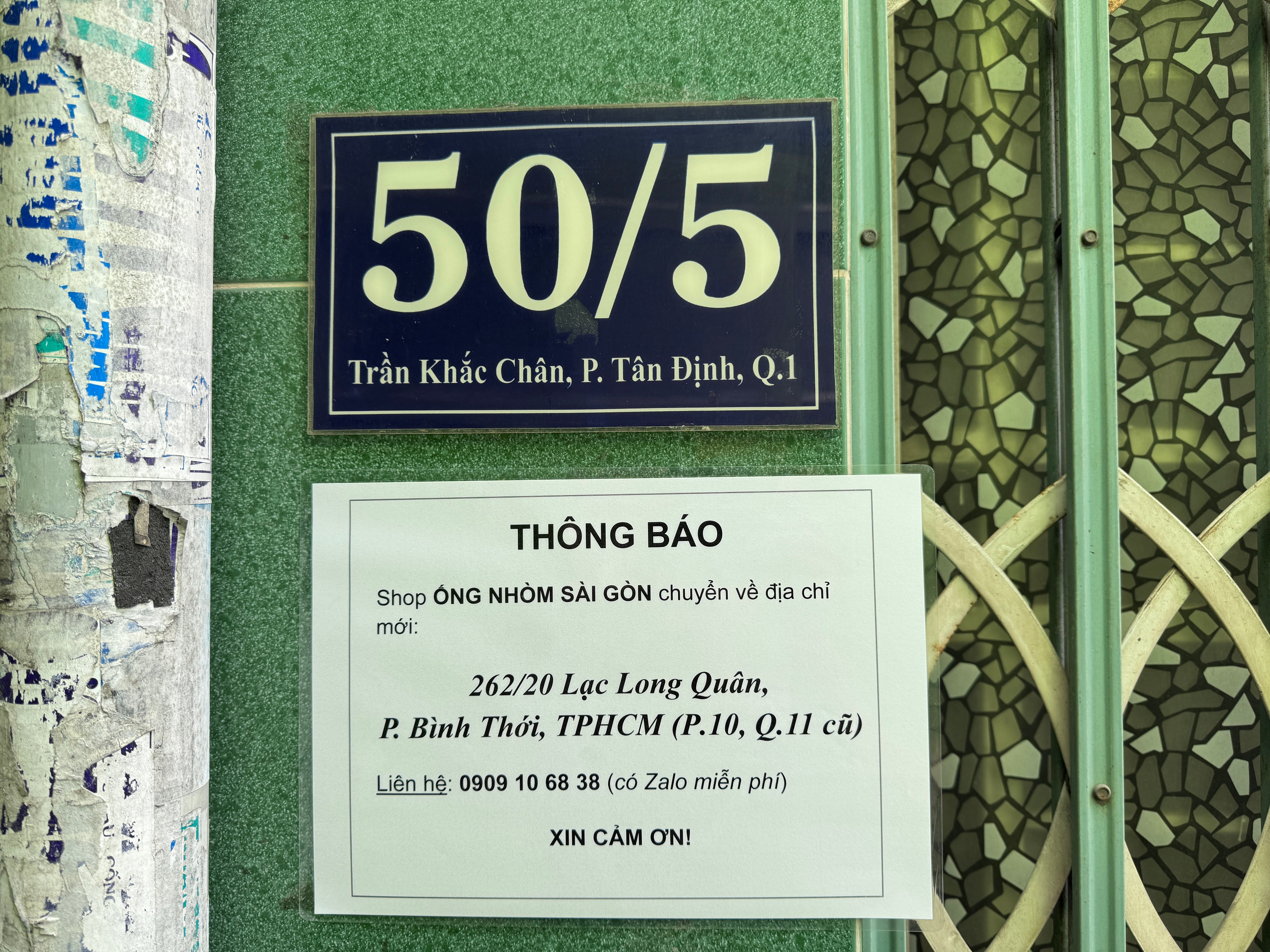 Biển thông báo chuyển về 262/20 Lạc Long Quân dán ngay dưới biển số nhà 50/5 Trần Khắc Chân.