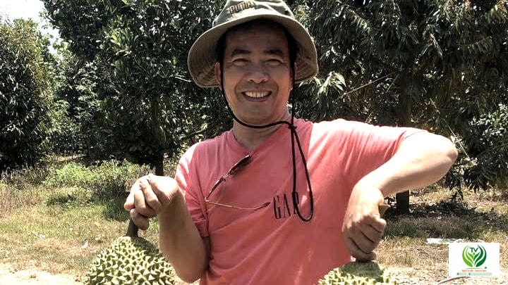 Người nông dân cầm sầu riêng tại vườn