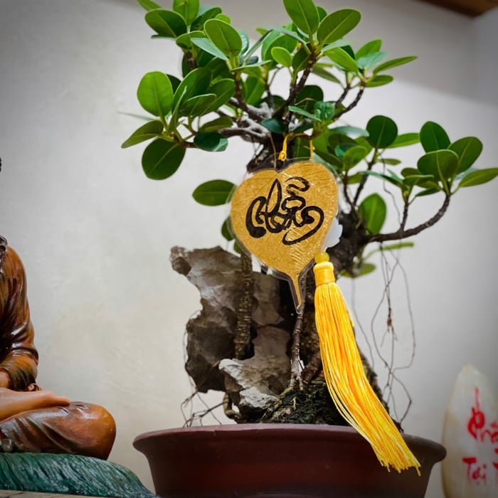 Lá bồ đề dát vàng viết tay chữ thư pháp chữ NHẪN có ép plastic 