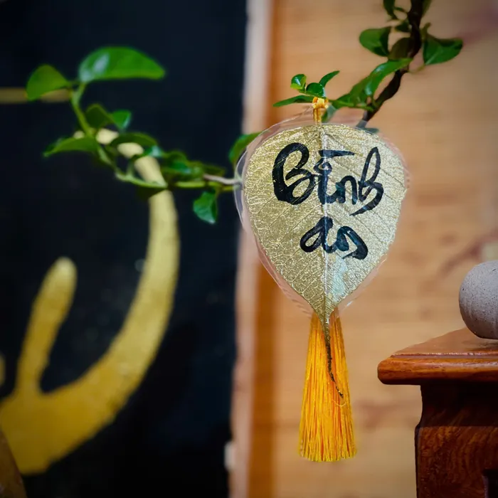 Lá bồ đề dát vàng viết tay chữ thư pháp chữ BÌNH AN có ép plastic bảo vệ trang trí nhà cửa decor ốp lưng treo xe size nhỏ