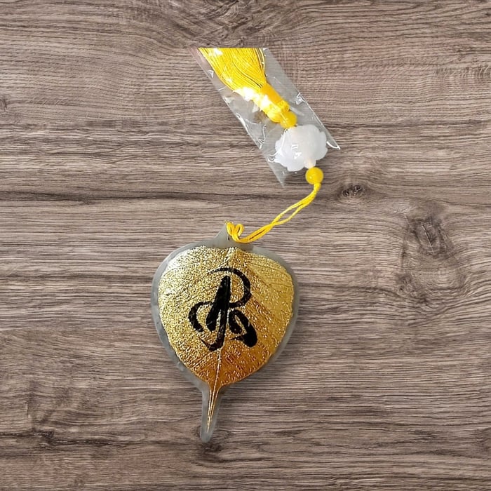 Lá bồ đề dát vàng viết tay chữ thư pháp chữ AN có ép plastic 