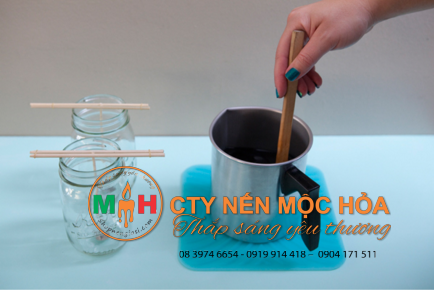 Cẩn thận đổ sáp nóng chảy vào lọ thủy tinh Cẩn thận đổ sáp nóng chảy vào lọ thủy tinh