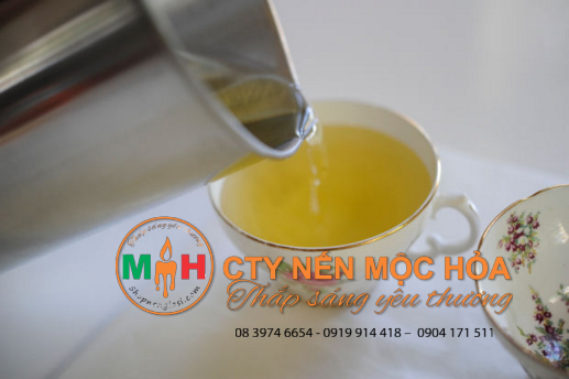 Đổ sáp nến tan chảy vào đầy các tách trà Đổ sáp nến tan chảy vào đầy các tách trà