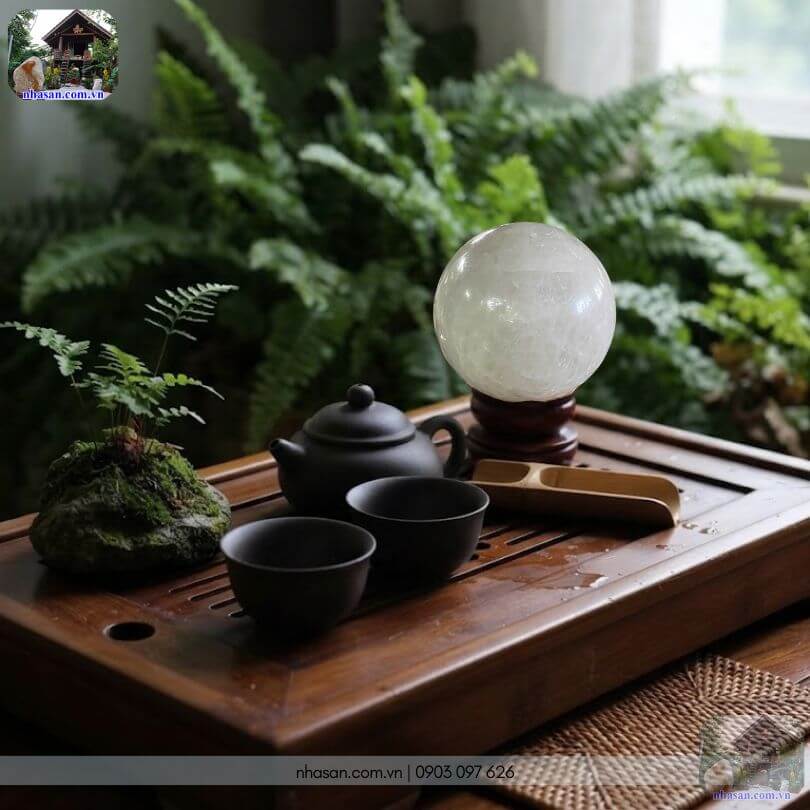 Bi cầu thạch anh trắng phong thủy đặt cạnh bộ ấm trà không gian xanh Bi cầu thạch anh trắng phong thủy đặt cạnh bộ ấm trà không gian xanh