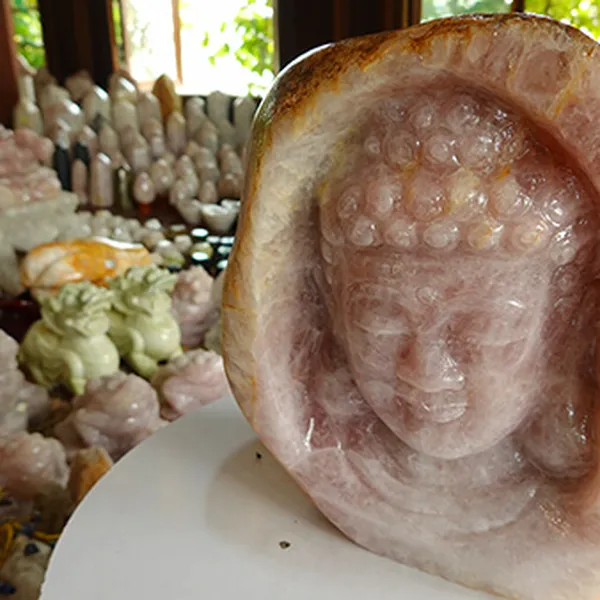 Sculpture of Shakyamuni Buddha on rose quartz pebbles