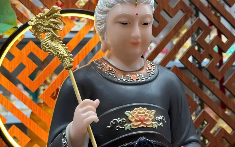 Bà Cố Hỷ tay cầm quả Đào