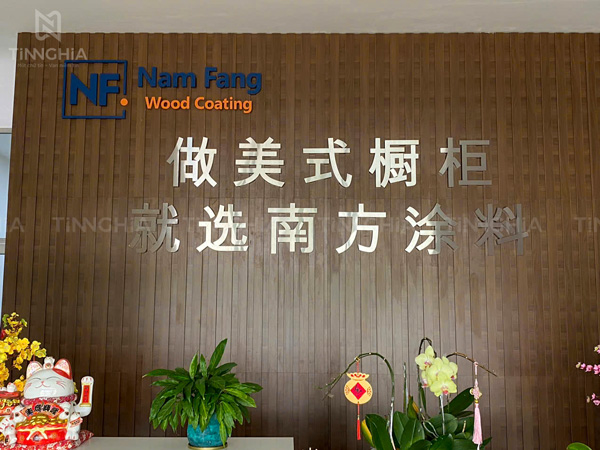 Backdrop gỗ lam sóng giả gỗ chữ nổi logo bằng inox bắt mắt