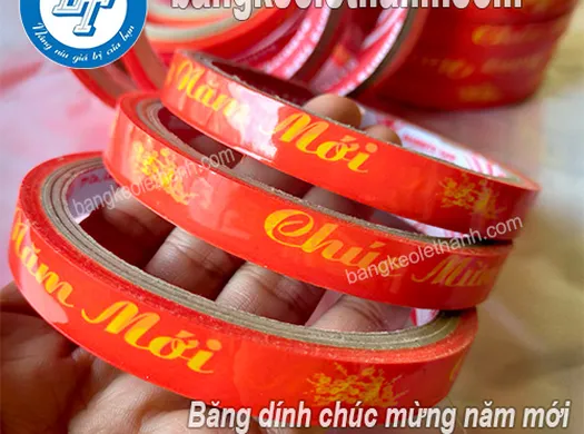 BÁN SỈ BĂNG DÍNH CHÚC MỪNG NĂM MỚI 1.2CM CÂY 24 CUỘN