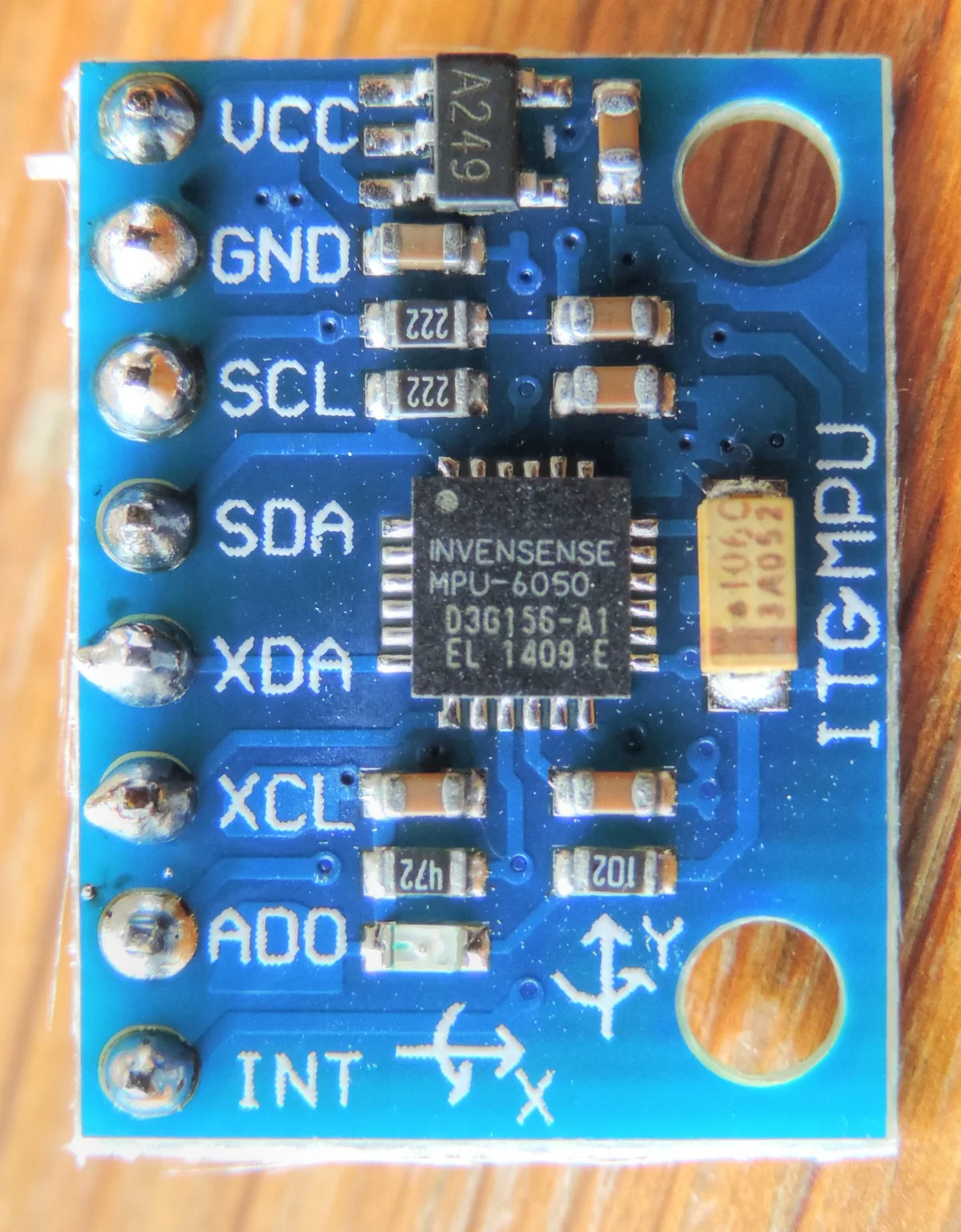 Module GY-521 màu xanh dương với chip MPU-6050 ở giữa, hàng chân VCC, GND, SCL, SDA, XDA, XCL, AD0, INT và ký hiệu trục X, Y in trên mạch