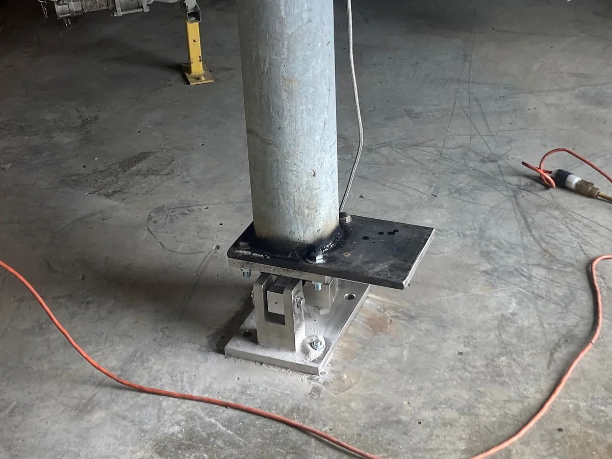 Load cell bằng thép lắp dưới chân bồn hóa chất, giữa hai tấm đế bắt bulông trên sàn bê tông, dây tín hiệu đi ra bên cạnh
