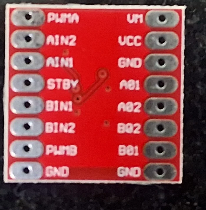 Mặt dưới module driver đôi TB6612FNG màu đỏ có in tên chân: bên trái PWMA, AIN2, AIN1, STBY, BIN1, BIN2, PWMB, GND; bên phải VM, VCC, GND, AO1, AO2, BO2, BO1, GND