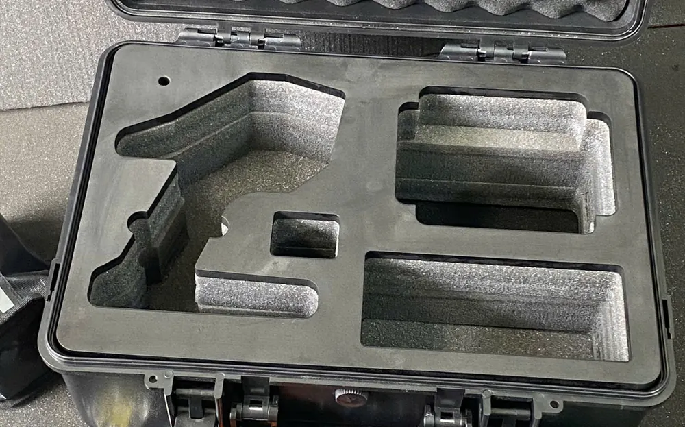 Cận cảnh khoang xốp chống sốc nhiều lớp cắt theo dáng tay điều khiển và các khoang chữ nhật có bậc
