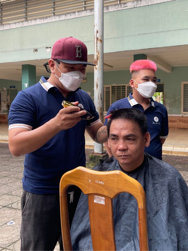 Ánh mắt ngờ nghệch và nụ cười vô tri của một bệnh nhân khi được khoác lên người tấm áo choàng cắt tóc Ánh mắt ngờ nghệch và nụ cười vô tri của một bệnh nhân khi được khoác lên người tấm áo choàng cắt tóc