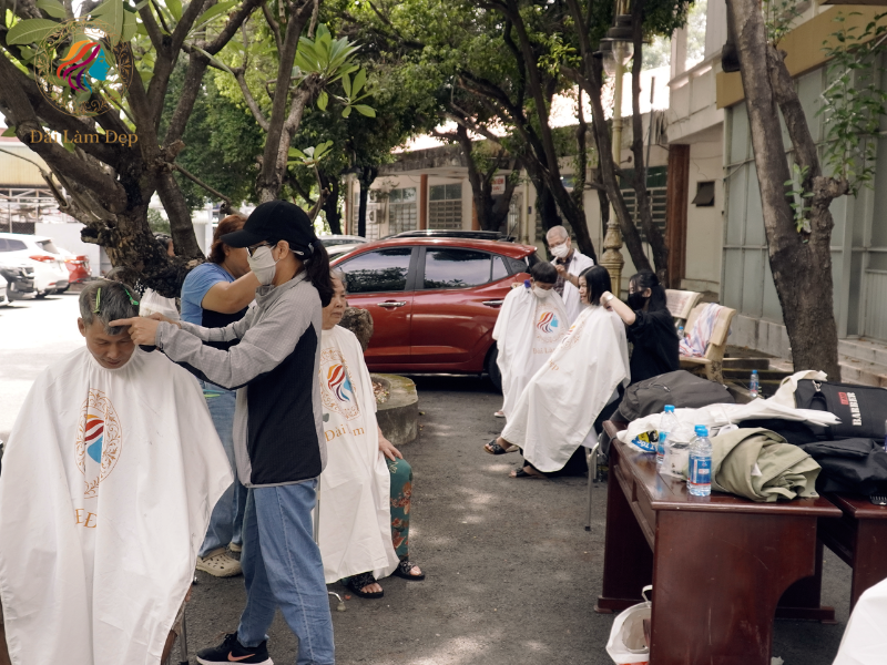 Không gian dã chiến trước sân bệnh viện được xếp ghế gọn gàng, người thợ của Salon Đài Làm Đẹp cẩn trọng từng thao tác Không gian dã chiến trước sân bệnh viện được xếp ghế gọn gàng, người thợ của Salon Đài Làm Đẹp cẩn trọng từng thao tác