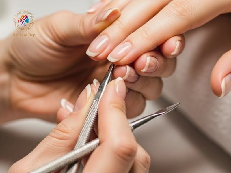Thợ nail đang tỉ mỉ cắt da tay và vệ sinh móng cho khách hàng Thợ nail đang tỉ mỉ cắt da tay và vệ sinh móng cho khách hàng