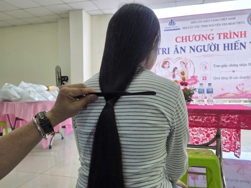 Thợ tóc hội Yes Beautiful đang dùng thước đo cẩn thận và buộc thun thật chặt để giữ lại tối đa chiều dài lọn tóc hiến Thợ tóc hội Yes Beautiful đang dùng thước đo cẩn thận và buộc thun thật chặt để giữ lại tối đa chiều dài lọn tóc hiến