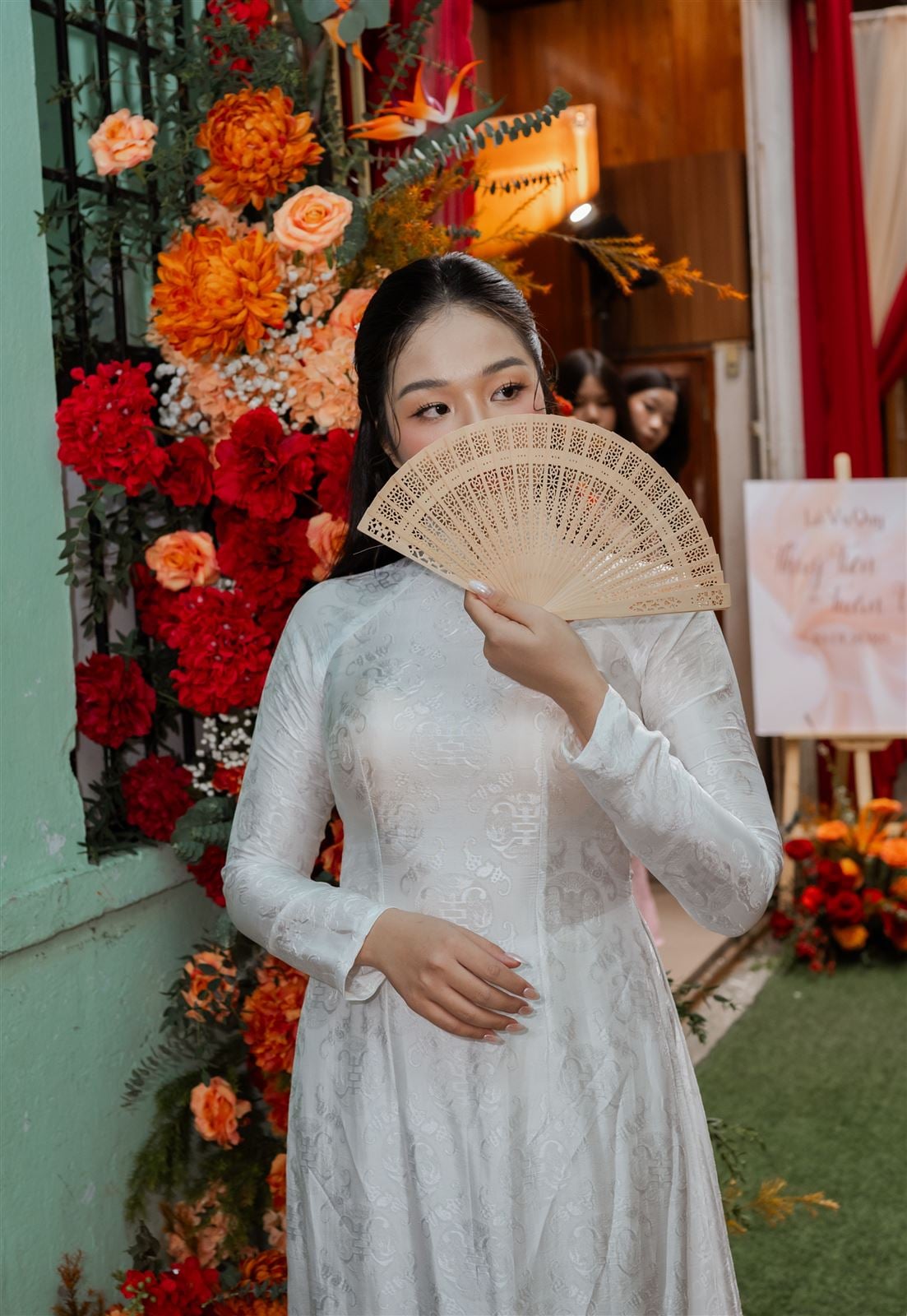 Cô dâu áo dài trắng trước cổng hoa