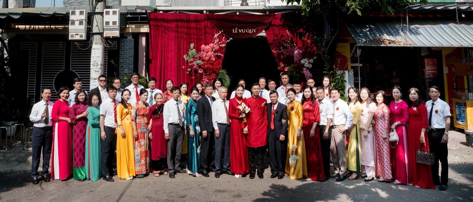 Họ hàng hai bên chụp chung trước cổng hoa nhà gái