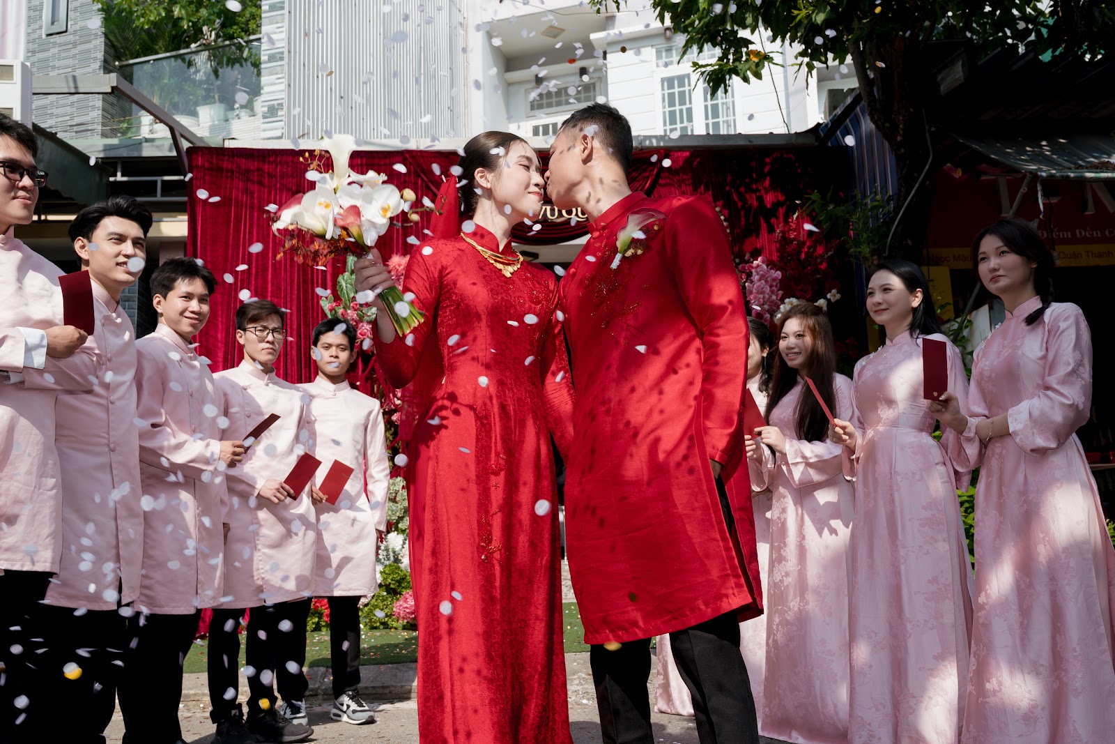 Cô dâu chú rể giữa dàn bê tráp áo dài hồng ngoài sân nhà gái