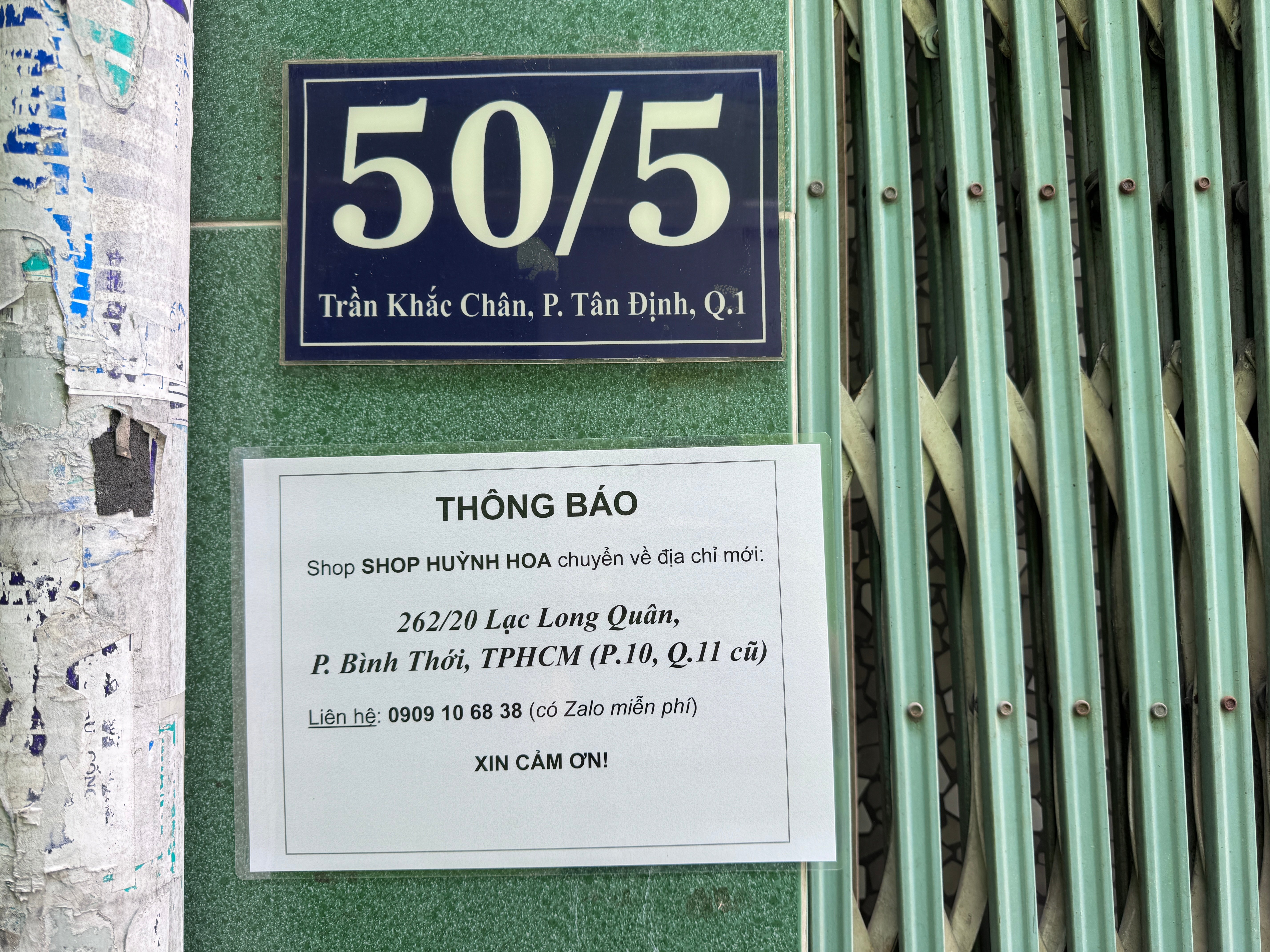 Biển thông báo chuyển về 262/20 Lạc Long Quân dán ngay dưới biển số nhà 50/5 Trần Khắc Chân.