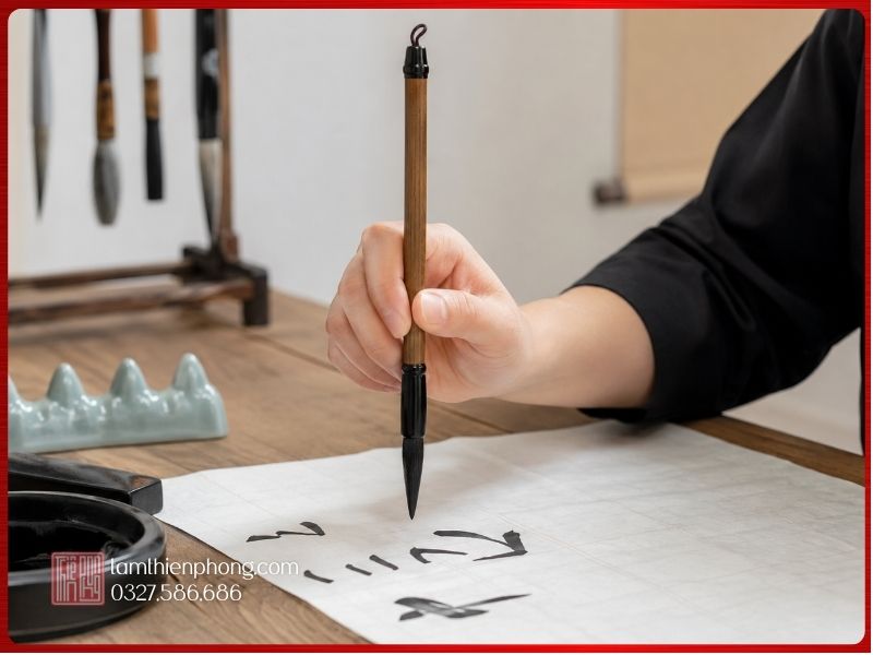 Cách cầm bút lông viết thư pháp đúng cho người mới Cận cảnh người mới học cách cầm bút lông viết thư pháp đúng trên giấy luyện chữ