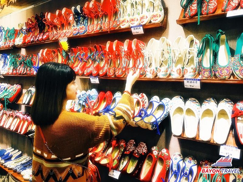 Du lịch đến Phượng Hoàng cổ trấn du khách có thể chọn những đôi giày thêu hoa với đủ hoạ tiết và màu sắc bắt mắt về làm quà Du lịch đến Phượng Hoàng cổ trấn du khách có thể chọn những đôi giày thêu hoa với đủ hoạ tiết và màu sắc bắt mắt về làm quà