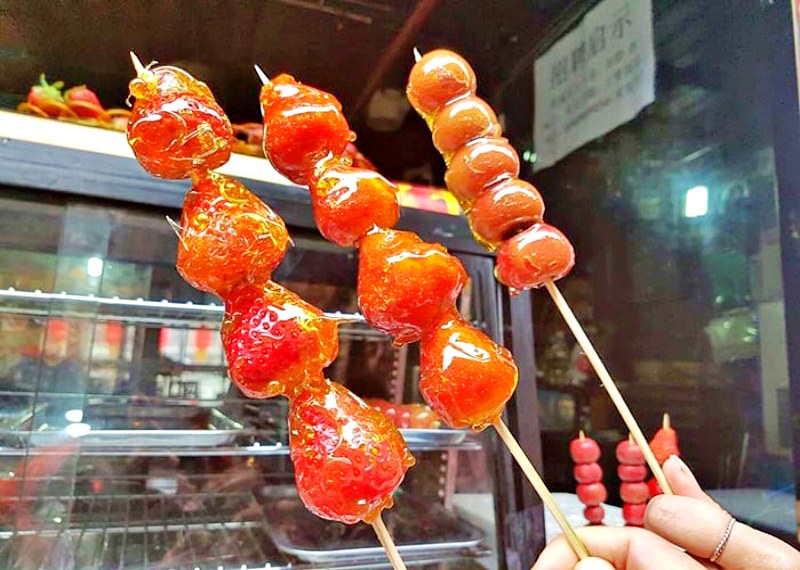 Du lịch Phượng Hoàng cổ trấn vào mùa thu: Kẹo hồ lô món ăn vặt truyền thống Trung Hoa được bày bán trên phố. Du lịch Phượng Hoàng cổ trấn vào mùa thu: Kẹo hồ lô món ăn vặt truyền thống Trung Hoa được bày bán trên phố.