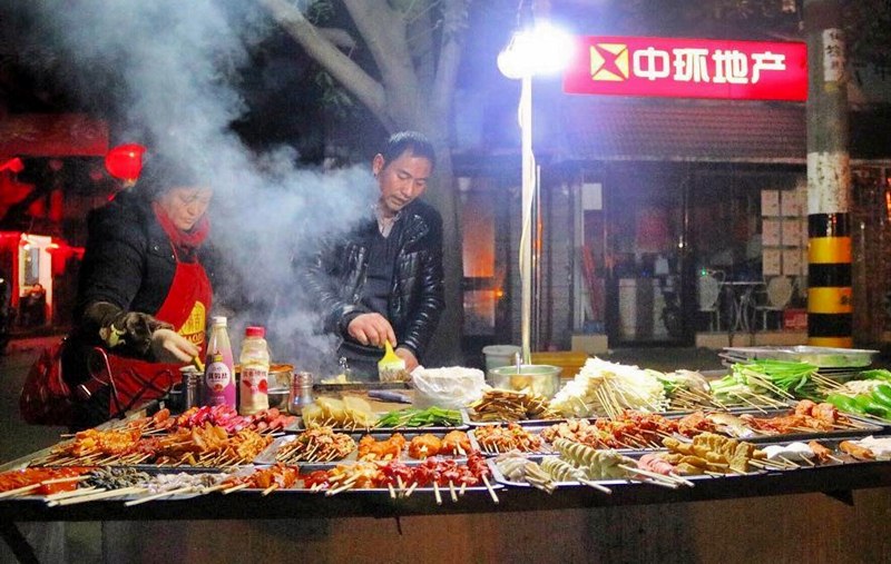 Khách du lịch sẽ bắt gặp món xiên nướng thơm lừng bày bán dọc các con phố đêm ở Phượng Hoàng Cổ Trấn Khách du lịch sẽ bắt gặp món xiên nướng thơm lừng bày bán dọc các con phố đêm ở Phượng Hoàng Cổ Trấn